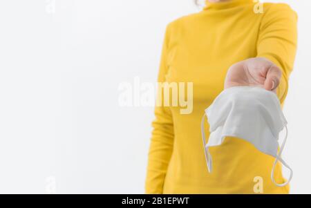 Frau hält eine Staubmaske, 2.5 isoliert auf weißem Hintergrund. Die Förderung von Menschen verwendet Gesichtsmaske, um sich vor Virusinfektionen in Corona zu schützen Stockfoto