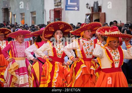 Frauen Teil von Huehues in traditionellen mexikanischen Kostümen im Tlaxcala Carnival, mit Sombreros und orangefarbenen Kleidern. Tlaxcala, Mexiko, Stockfoto