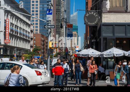 Fußgänger, die die Straße im Crosswalk an der W 21st Street und der 6th Avenue Chelsea, New York USA überqueren Stockfoto