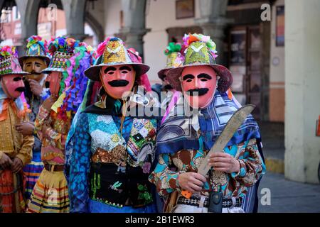Zwei Tänzerinnen sind Teil eines Cuchillos (Messer) Wurfs von Huehues in traditionellen mexikanischen Kostümen im Tlaxcala Carnival. Tlaxcala, Mexiko Stockfoto