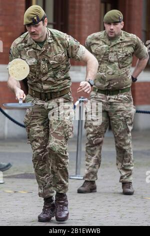 Windsor, Großbritannien. Februar 2020. Ein Soldat der 1st Battalion Welsh Guards zeigt seine Flipping-Fähigkeiten und seine ausgefallene Fußarbeit, als er am Dienstag in Shrove in der Windsor and Eton Flippin' Pancake Challenge um die Unterstützung des Alexander Devine Children's Hospice Service konkurriert. Credit: Mark Kerrison/Alamy Live News Stockfoto