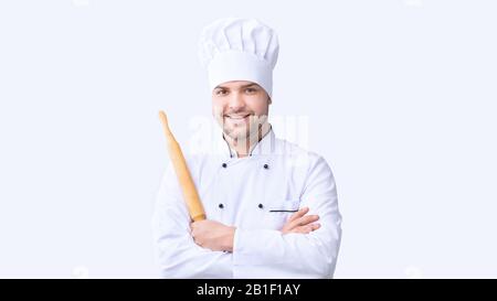 Fröhlicher Baker Holding Doug Rolling Pin Auf Weißem Hintergrund, Panorama Stockfoto