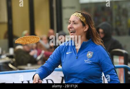 Eastbourne UK 25. Februar 2020 - EIN Mitglied des Eastbourne Academy Teams in Aktion bei den jährlichen Eastbourne Pancake Rennen, die jeden Shrove Dienstag stattfinden, um Geld für das örtliche St Wilfred's Hospice zu sammeln: Credit Simon Dack / Alamy Live News Stockfoto