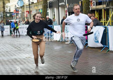 Eastbourne UK 25. Februar 2020 - Aktion aus den jährlichen Eastbourne Pancake-Rennen, die jeden Shrove Dienstag stattfinden, um Geld für das lokale St Wilfred's Hospice zu sammeln: Credit Simon Dack/Alamy Live News Stockfoto