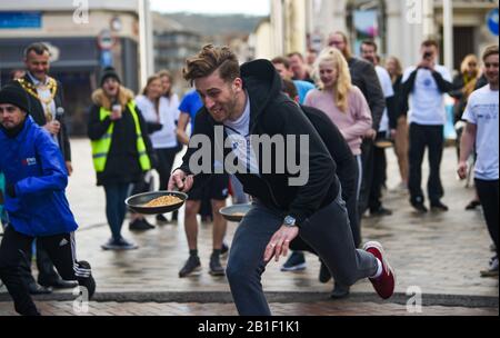 Eastbourne UK 25. Februar 2020 - Aktion aus den jährlichen Eastbourne Pancake-Rennen, die jeden Shrove Dienstag stattfinden, um Geld für das lokale St Wilfred's Hospice zu sammeln: Credit Simon Dack/Alamy Live News Stockfoto