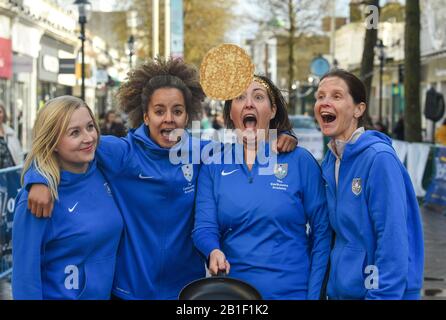 Eastbourne UK 25. Februar 2020 - Mitglieder des Teams der Eastbourne Academy in Aktion bei den jährlichen Eastbourne Pancake-Rennen, die jeden Shrove Dienstag stattfinden, um Geld für das lokale St Wilfred's Hospice zu sammeln: Credit Simon Dack / Alamy Live News Stockfoto