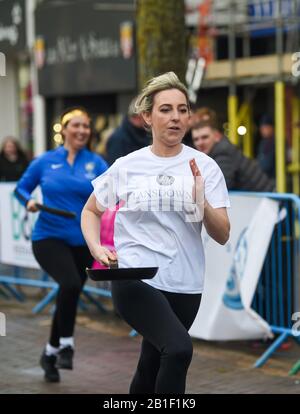 Eastbourne UK 25. Februar 2020 - Aktion aus den jährlichen Eastbourne Pancake-Rennen, die jeden Shrove Dienstag stattfinden, um Geld für das lokale St Wilfred's Hospice zu sammeln: Credit Simon Dack/Alamy Live News Stockfoto