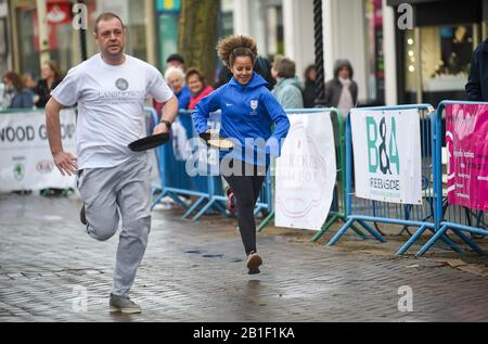 Eastbourne UK 25. Februar 2020 - Aktion aus den jährlichen Eastbourne Pancake-Rennen, die jeden Shrove Dienstag stattfinden, um Geld für das lokale St Wilfred's Hospice zu sammeln: Credit Simon Dack/Alamy Live News Stockfoto