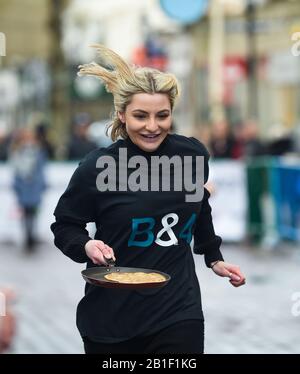 Eastbourne UK 25. Februar 2020 - Aktion aus den jährlichen Eastbourne Pancake-Rennen, die jeden Shrove Dienstag stattfinden, um Geld für das lokale St Wilfred's Hospice zu sammeln: Credit Simon Dack/Alamy Live News Stockfoto