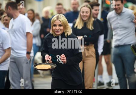 Eastbourne UK 25. Februar 2020 - Aktion aus den jährlichen Eastbourne Pancake-Rennen, die jeden Shrove Dienstag stattfinden, um Geld für das lokale St Wilfred's Hospice zu sammeln: Credit Simon Dack/Alamy Live News Stockfoto