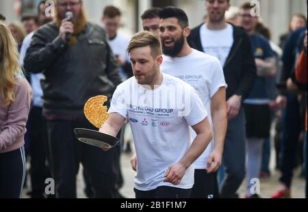 Eastbourne UK 25. Februar 2020 - Aktion aus den jährlichen Eastbourne Pancake-Rennen, die jeden Shrove Dienstag stattfinden, um Geld für das lokale St Wilfred's Hospice zu sammeln: Credit Simon Dack/Alamy Live News Stockfoto