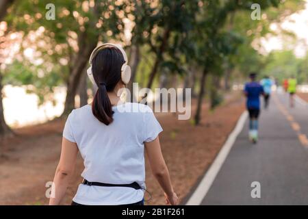 Frauen trainieren im Park und hören mit Kopfhörern. Stockfoto