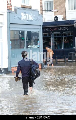 Shrewsbury, Shropshire, Großbritannien - Dienstag, 25. Februar 2020 - Einheimische wehten durch das Hochwasser im Stadtteil Coleham der Stadt mit ihren Schuhen in den Händen. Der Fluss Severn wird später heute seinen Höhepunkt erreichen, und für Shrewsbury gilt derzeit eine "Severn Flood Warning". Foto Steven May / Alamy Live News Stockfoto