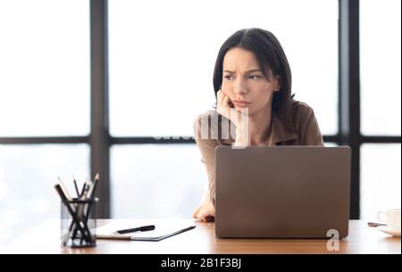 Junger europäischer Manager, der auf den Arbeitsplatz blickt Stockfoto