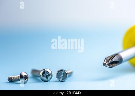 Nahaufnahme des Schraubendrehers sind Kreuz und verschiedene Schrauben. Werkzeuge. Kompatibilität. Reparieren. Speicherplatz kopieren Stockfoto