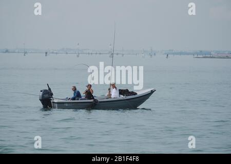 Venedig, Italien, Freunde, die in der Lagune von Venedig fischen, drei Männer in einem kleinen offenen Boot mit Außenbordmotor in der Nähe der Insel Burano Stockfoto