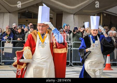 Guildhall, London, Großbritannien. Februar 2020. Die Teilnehmer Rennen mit ihren Pfannen in der Hand. Shrove Tuesday, auch bekannt als "Pancake Day", sieht Teams von Teilnehmern aus den Liveries der City of London in ihren Regalien und ihrem schicken Kleid an, während sie sich bei Pfannkuchenrennen gegenseitig anziehen. Die jährliche Tradition findet außerhalb der Guildhall der Stadt statt. Kredit: Imageplotter/Alamy Live News Stockfoto