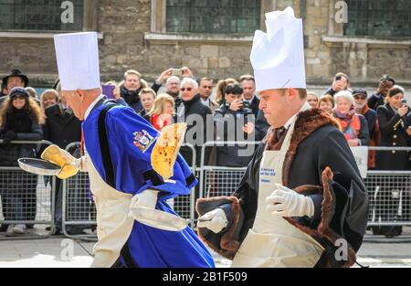 Guildhall, London, Großbritannien. Februar 2020. Die Teilnehmer Rennen mit ihren Pfannen in der Hand. Shrove Tuesday, auch bekannt als "Pancake Day", sieht Teams von Teilnehmern aus den Liveries der City of London in ihren Regalien und ihrem schicken Kleid an, während sie sich bei Pfannkuchenrennen gegenseitig anziehen. Die jährliche Tradition findet außerhalb der Guildhall der Stadt statt. Kredit: Imageplotter/Alamy Live News Stockfoto