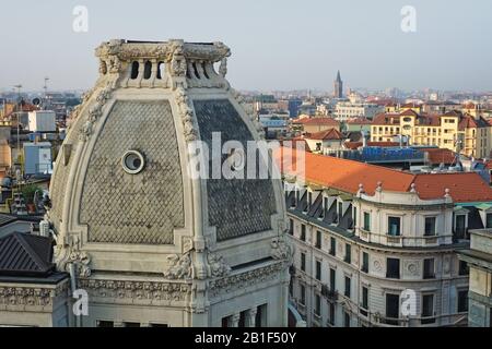 Ein enger Blick auf die Balustrade überragte die Dachkuppel des Palazzo Meroni - Löwen und Blumengarlands, Okulifenster und die Stadt Mailand im Hintergrund Stockfoto