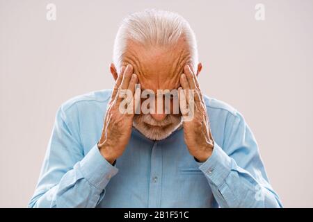 Porträt eines älteren Mannes, der Kopfschmerzen hat. Stockfoto