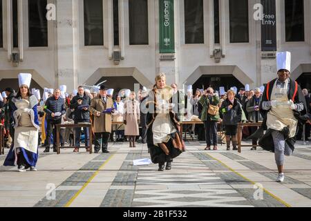 Guildhall, London, Großbritannien. Februar 2020. Die Teilnehmer Rennen mit ihren Pfannen in der Hand. Shrove Tuesday, auch bekannt als "Pancake Day", sieht Teams von Teilnehmern aus den Liveries der City of London in ihren Regalien und ihrem schicken Kleid an, während sie sich bei Pfannkuchenrennen gegenseitig anziehen. Die jährliche Tradition findet außerhalb der Guildhall der Stadt statt. Kredit: Imageplotter/Alamy Live News Stockfoto