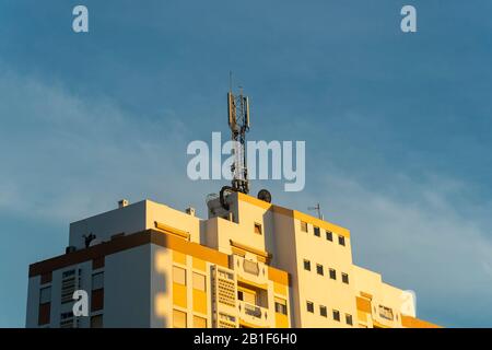 Apartmenthaus mit einem Fernmeldemast auf der Oberseite Stockfoto