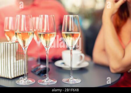 Nahdetailtisch mit vielen gefüllten Gläsern weißem Champagner bei Partyfeiern im Freien. Leute, die Spaß haben, genießen Alkohol Stockfoto