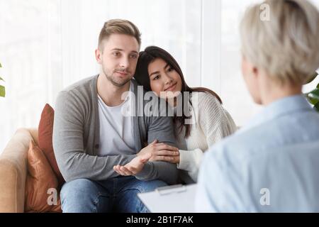 Ehepartner, Die Sich Nach Erfolgreicher Therapie Versöhnen, Sitzen Im Psychotherapeutenbüro Stockfoto