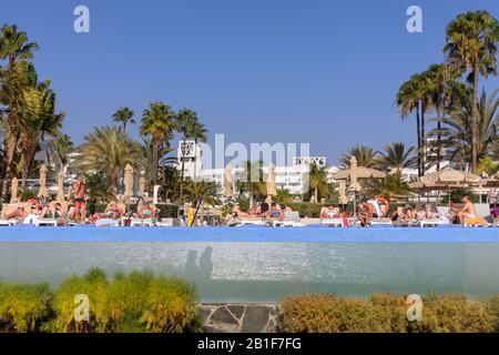 Touristen sonnen sich am Pool des Hotel Riu Palace Meloneras, Gran Canaria, Kanarische Inseln, Spanien Stockfoto