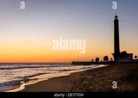Sonnenuntergang am Strand von Maspalomas und Leuchtturm in Silhouette, Gran Canaria, Kanarische Inseln Stockfoto