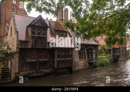 Ein Haus mit Holzfassade steht an einem Kanal in Brüggen neben der romantischen Bonifazius-Brücke, ein idealer Ort für Fotos. Stockfoto