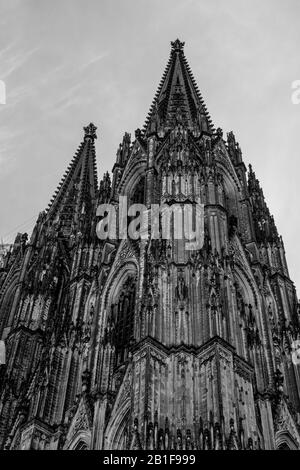 Bis zum Himmel reicht die Fassade des gotischen Kölner Doms mit seinen zwei Türmen. Das Schwarz-Weiß-Foto zeigt die Zeitlosigkeit. Stockfoto