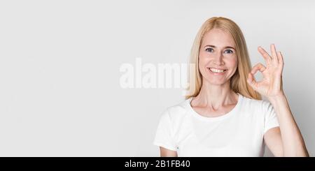 Fröhliche reife Frau gestikuliere ein gutes Zeichen und lächelte Stockfoto