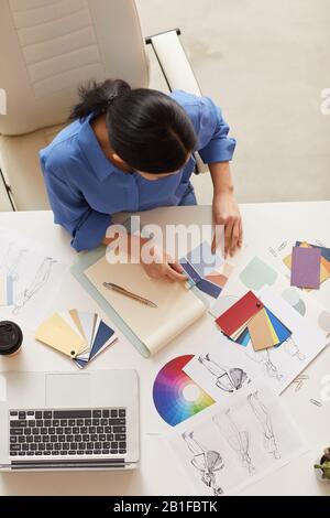 Hochwinkelige Ansicht bei Geschäftsfrau, die Dokument hält, während sie am Tisch sitzt, Kopierraum Stockfoto