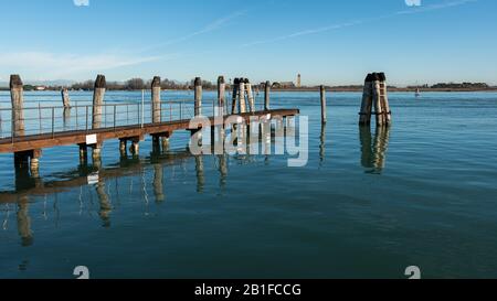 Jetty und Holzbollard in der Lagune von Venedig (Italien) an einem sonnigen Tag im Winter Stockfoto