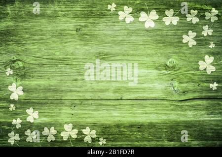 Shamrocks auf grünem Holztisch ein Symbol und St. Patricks Day. Bbanner mit Eckrand von Shamrocks. Strukturiertes Muster Stockfoto