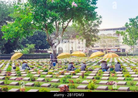 Kanchanaburi THAILAND - 21. FEBRUAR: Unidentifizierte Arbeiter renovieren und dekorieren Blumen auf dem Allied war Cemetery von Kanchanaburi am 21.2020 in Ka Stockfoto