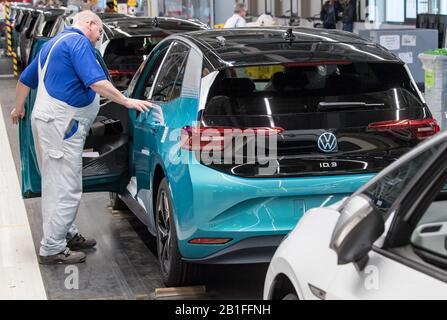 25. Februar 2020, Sachsen, Zwickau: Mitarbeiter von Volkswagen Sachsen in Zwickau vervollständigen den VW ID.3. Anfang November 2019 initiierte Volkswagen mit Produktionsstart der ID.3 die Systemänderung zur Elektromobilität. Das Fahrzeug ist das erste Modell der vollelektrischen ID-Familie und soll das Massengeschäft mit Elektrofahrzeugen beim weltgrößten Hersteller etablieren. In diesem Jahr will VW rund 100.000 Elektroautos in Zwickau mit dem modularen Elektroinstallationssatz herstellen. Ab Sommer soll das Fahrzeug europaweit zum Kauf angeboten werden. Rund 8000 Menschen Stockfoto