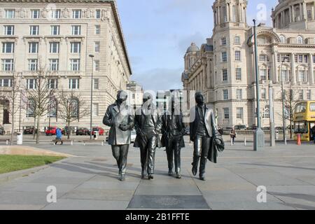 Touristen posieren mit einer Bronzestatue der beatles neben dem mersey in liverpool england UK Stockfoto