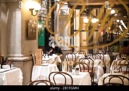 Ein Tourist trägt eine Schutzmaske im Restaurant Biffi in der Galleria Vittorio inmitten von Coronavirus Fears.Nach dem regionalen Dekret, das die Schließung nach 18:00 Uhr von Bars, Diskotheken, Pubs und auch Museen, Kinos fordert, als drastische Maßnahme zur Eindämmung der Verbreitung von COVID-19, wurden nur Restaurants und kommerzielle Plätze offen gelassen. Die Sperre dauert mindestens sieben Tage (bis zum 1. März). Stockfoto