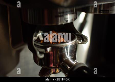 Espresso Maschine Mahlen Kaffeebohnen in Filter. Maschine gemahlenen Kaffee, Stockfoto