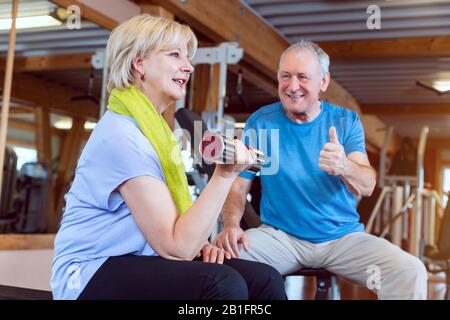 Seniorin im Fitnessstudio trainieren mit Hanteln für Fitness Stockfoto