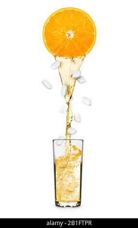 Saft fließt aus einer Orange mit fallenden Pillen in Glas.Konzeptfoto in der Kategorie der Vitamine Stockfoto