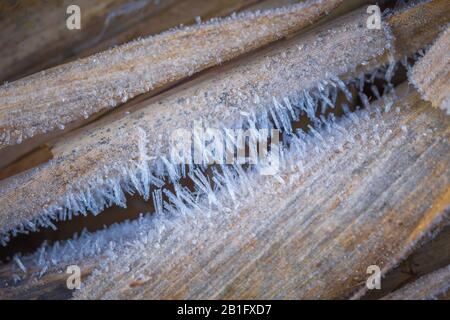 Texturhintergrund, Muster. Eiskristalle sind auf den Grashalmen detailliert. Anlagerung von kleinen weißen Eiskristallen, die sich auf dem Boden oder anderen Oberflächen bilden Stockfoto