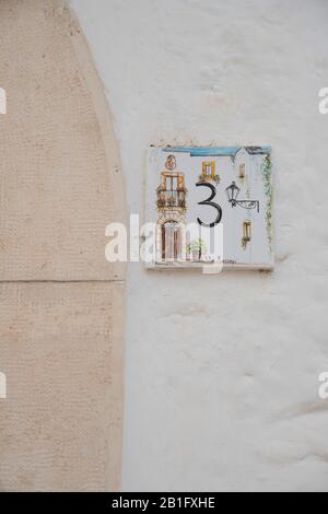 Eine handgemalte Kachel mit Hausnummer und lokaler Szene im Centro Storico, Locorotondo, Valle d'Itria, Taranto, Apulien, Italien, Europa Stockfoto