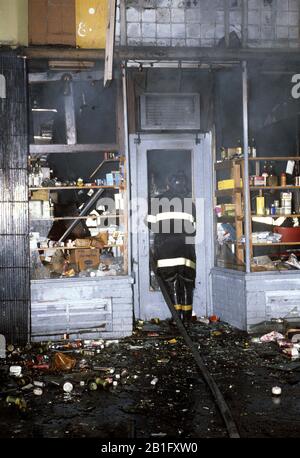 New York City Feuerwehrmann, der sich mit Brandanschlag im South Bronx Shop in New York City befasst Stockfoto