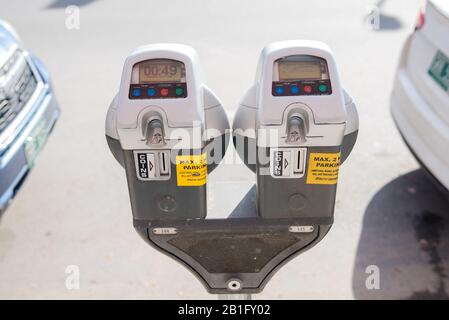 Nahaufnahme von zwei Parkmetern entlang einer Straße an einem sonnigen Herbsttag Stockfoto