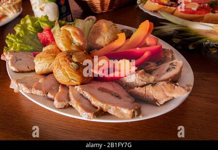 Teller mit köstlichen Snacks auf dem Tisch in einem Café. Tapas, Vorspeisen am Buffettisch in einem Restaurant. Burger, gebackenes gefülltes Fleisch mit Gewürzen, Scheibe Stockfoto