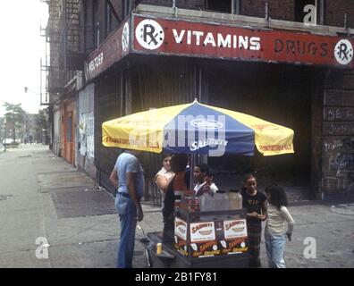 Hot Dog Verkäufer in South Bronx vor Burn Out Shops und Mietsblock, New York City Stockfoto