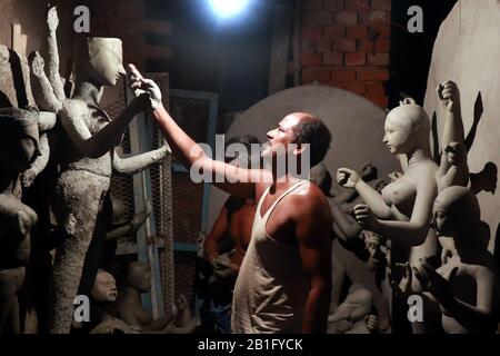 Ein Töpfer, der mit Konzentration in seinem Workshop arbeitet, um das Idol der Göttin Durga vor bengalis größtem Festival Durga Puja vorzubereiten. Stockfoto